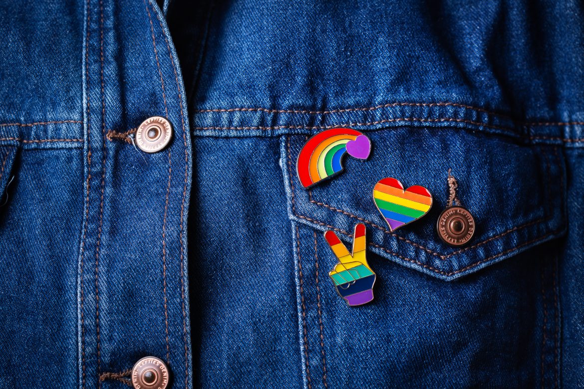Rainbow lgbtq flag badges against denim background, pride month
