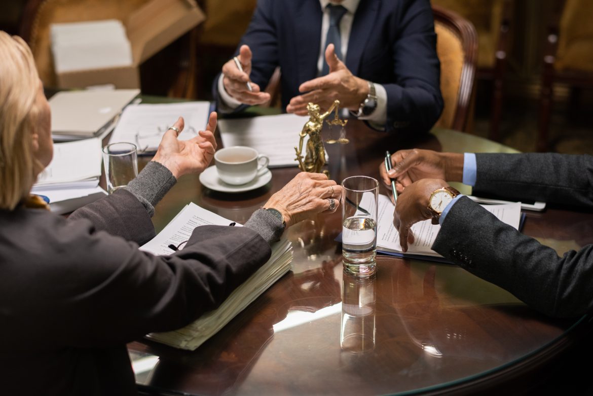 Hands of three contemporary lawyers during discussion