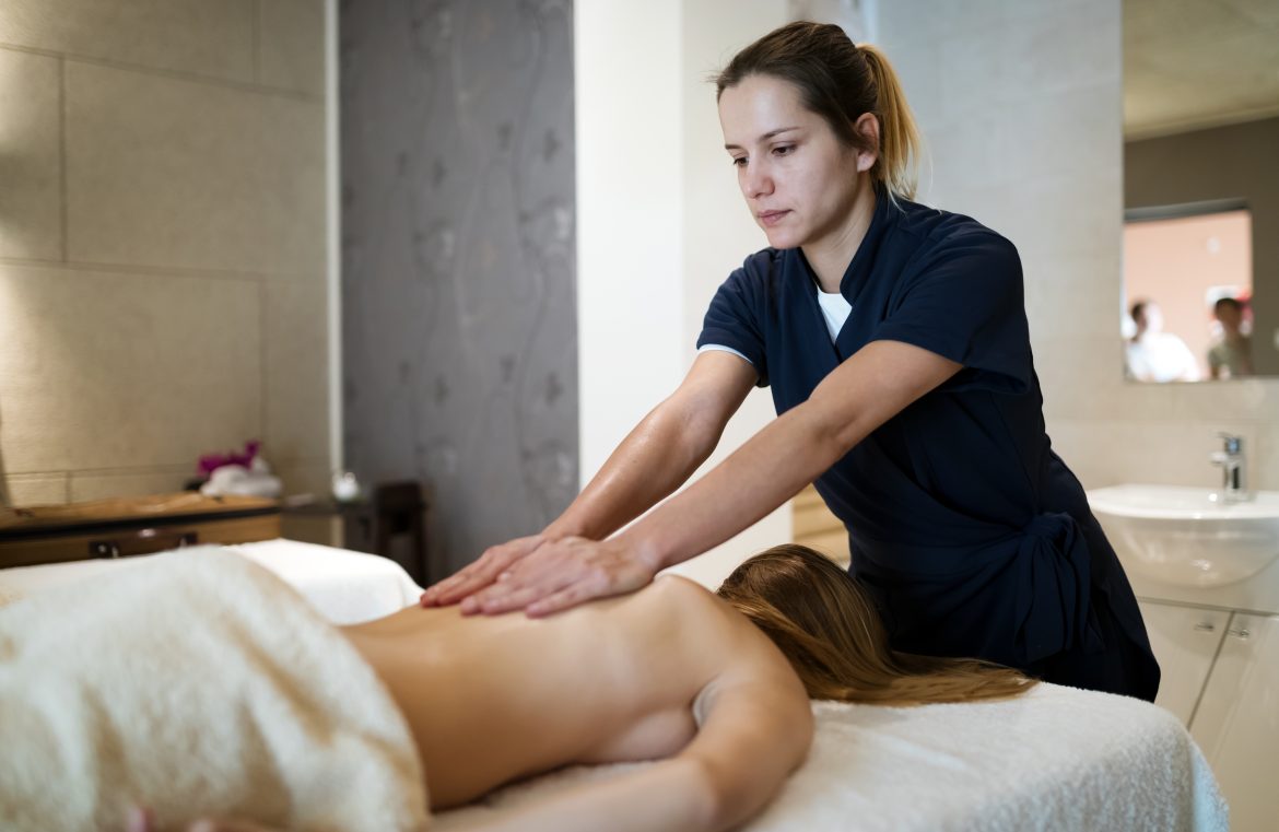 Masseur massaging back of female