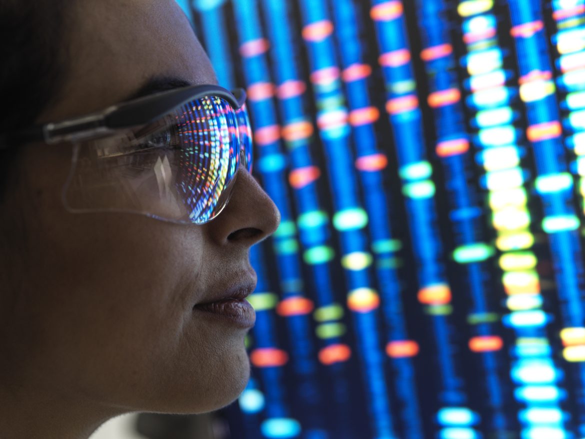 Genetic Research, female scientist viewing a DNA profile of a human sample on a screen in the lab.
