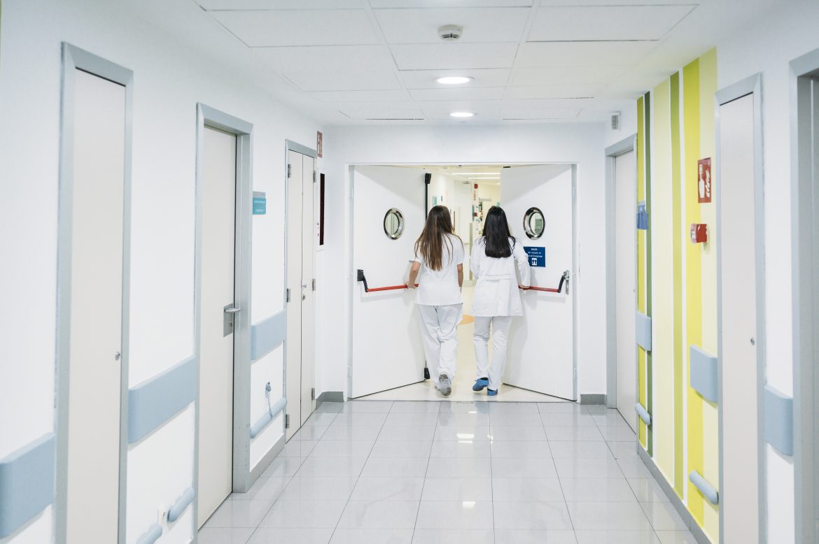 Nurse and doctor walking along the corridor of the hospital –
