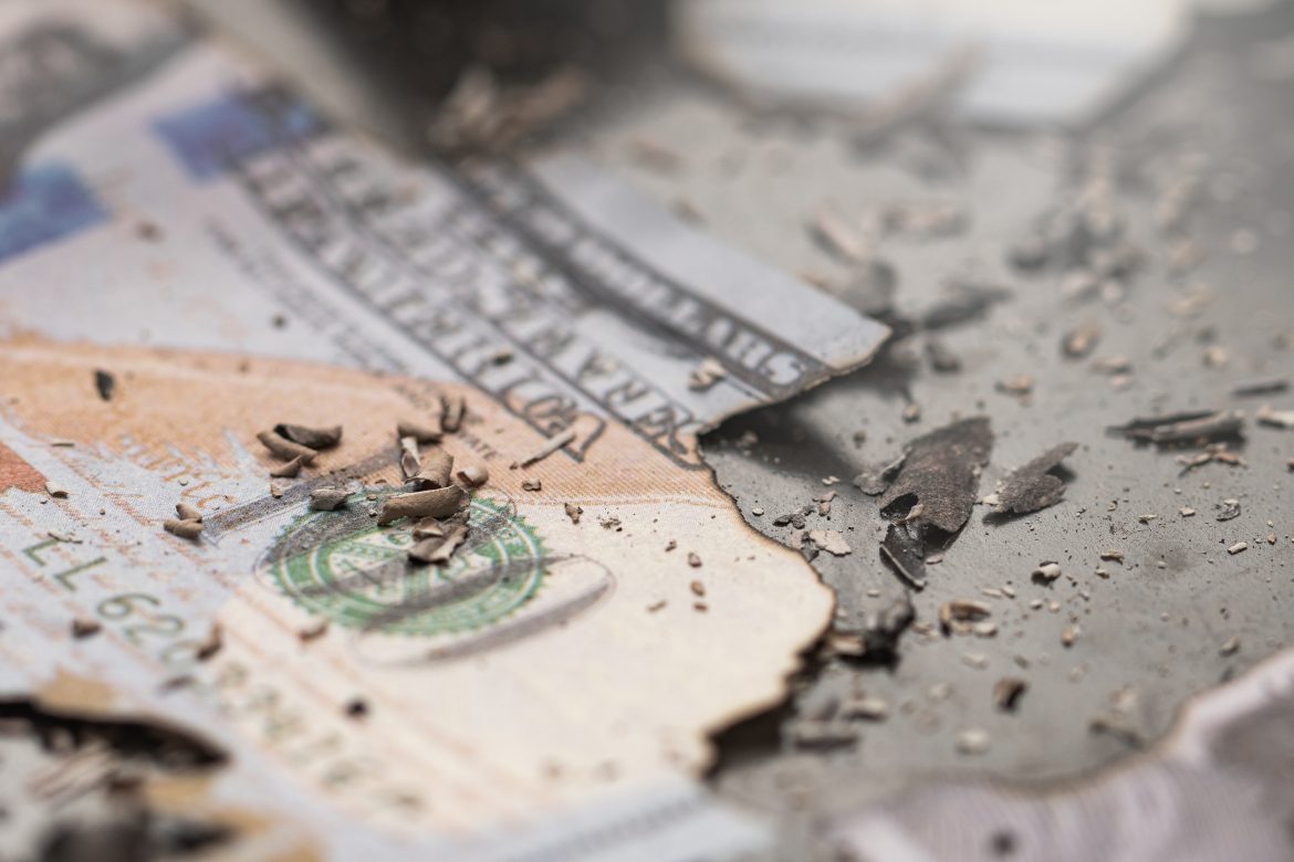Remains of burnt one hundred dollar bills reduced to ashes symbo